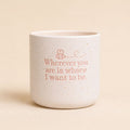 Neutral ceramic quote planter with “Wherever you are is where I want to be” on beige background