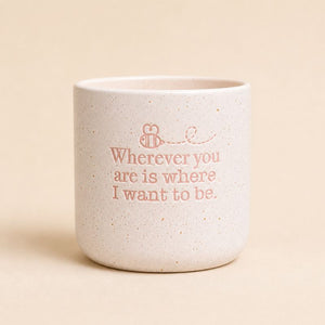 Neutral ceramic quote planter with “Wherever you are is where I want to be” on beige background