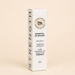 Box of 'Strength' essential oil roller with branding on a beige background