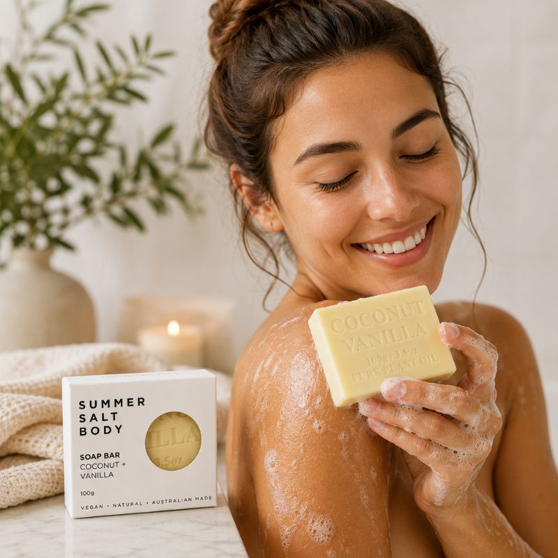 Woman applying soap to her skin with a 'Summer Salt Body' soap bar in the foreground.