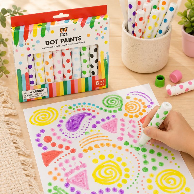Colorful Tiger Tribe dot paint set with packaging, paintbrushes, and child's hand making designs on paper. - Loveshack Giftware