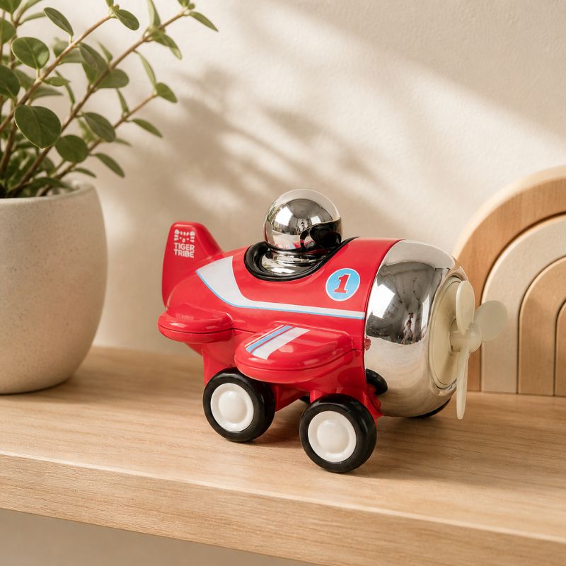 Child playing with Tiger Tribe Presto Plane push toy on wooden surface