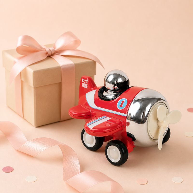 Tiger Tribe red toy airplane beside gift box with ribbon