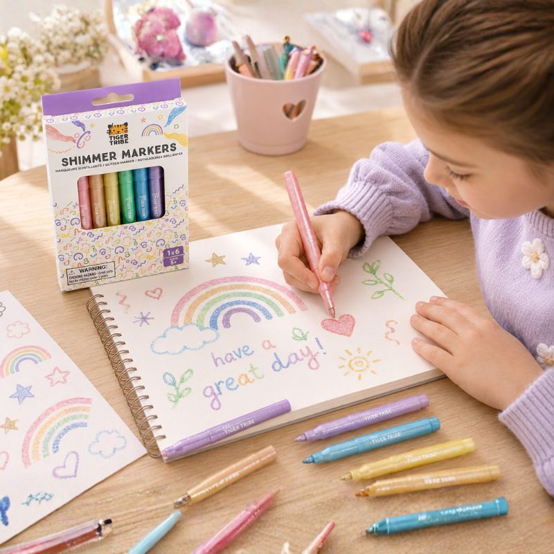 Child coloring with OOLY Shimmer Markers on a table with markers and a notebook.-Loveshack Giftware