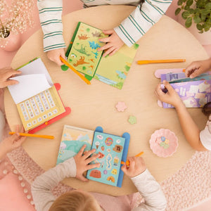 Children engaged in educational activities with books and pencils at a table.