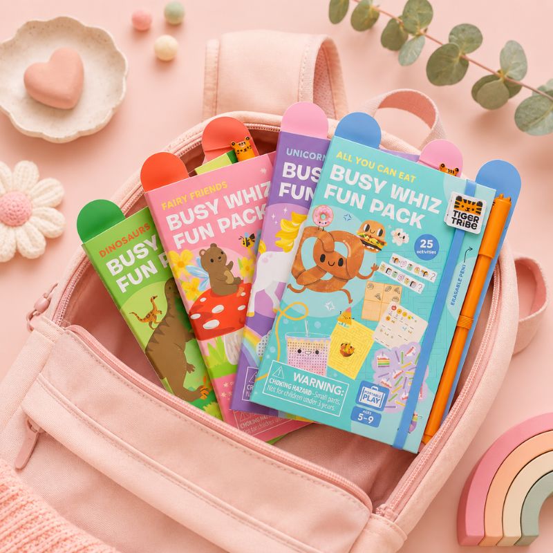Colorful 'Busy Whiz' fun packs in a pink bag with decorative elements on a pink background. - Loveshack Giftware