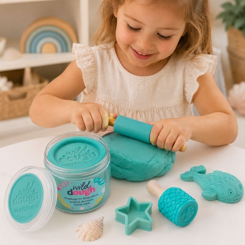 A child playing with toffee apple Play-Doh—Jar 280 gm and tools on a table.