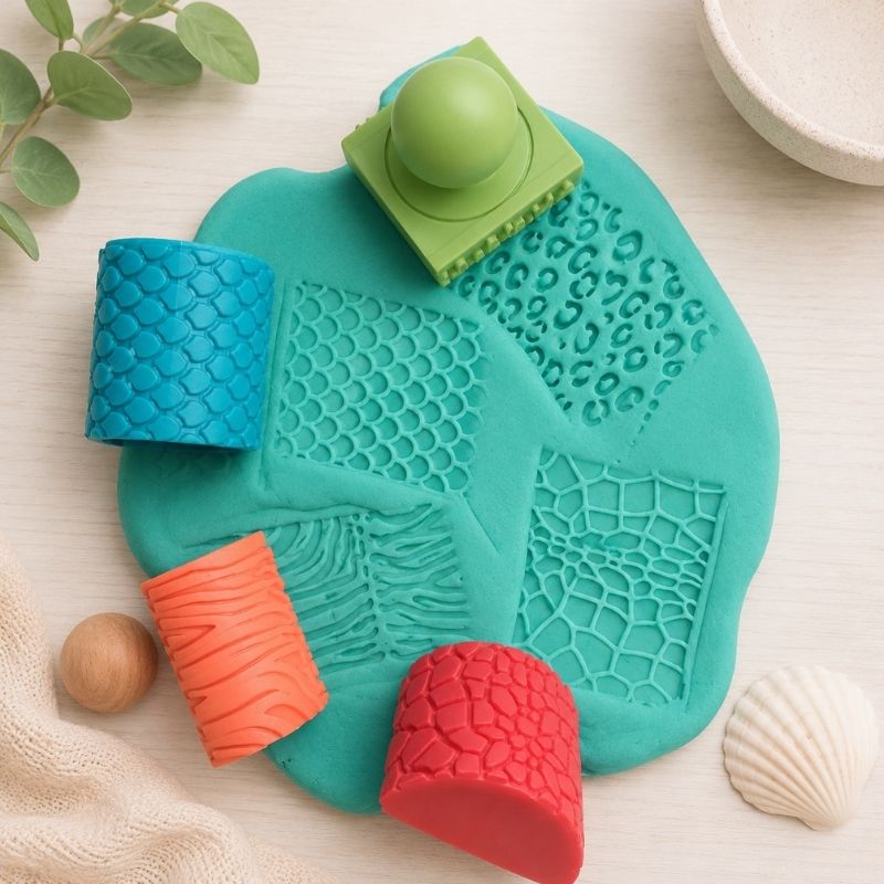 Teal turtle-shaped silicone mat with colorful textured pieces on a light surface.
