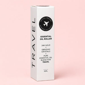 White essential oil roller packaging with black text on a pink background