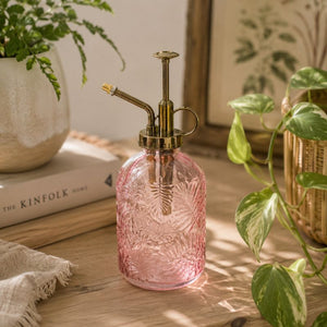 Pink glass plant spray bottle on a wooden surface with plants and books in the background-Loveshack Giftware