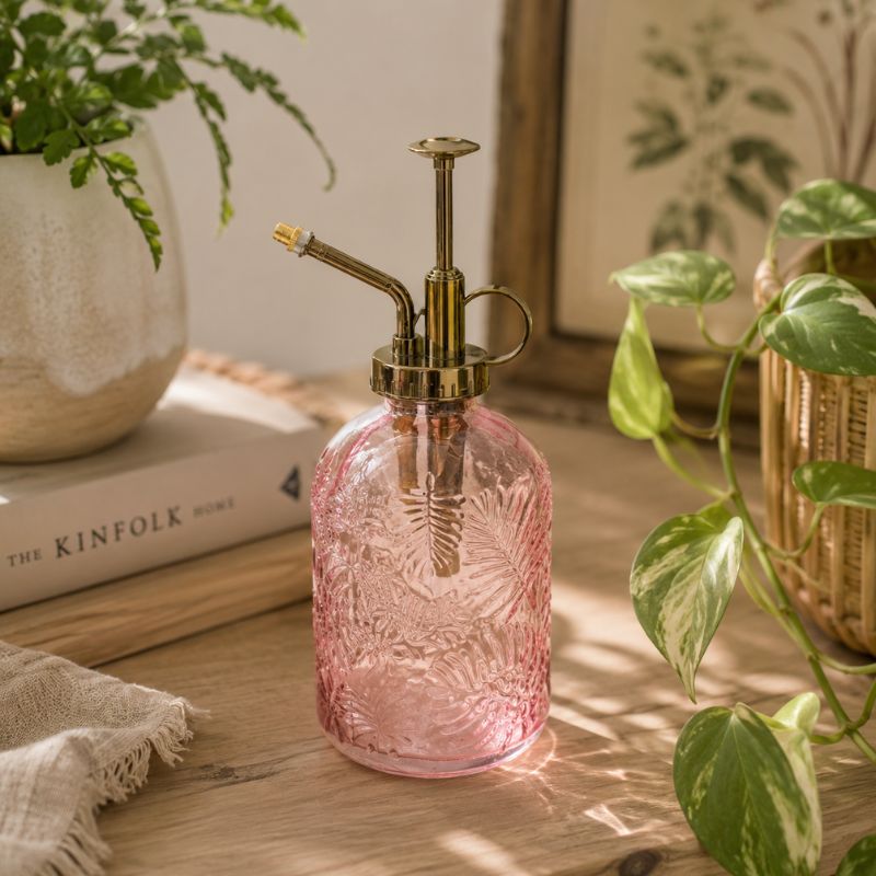 Pink glass plant spray bottle on a wooden surface with plants and books in the background-Loveshack Giftware