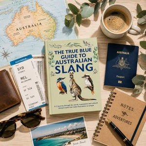 The True Blue Guide to Australian Slang book surrounded by Australian travel essentials including passport, map, and coffee