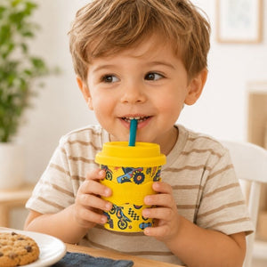 Child drinking from a Wheelies Babychino Cup 4oz with a blue straw in a home setting