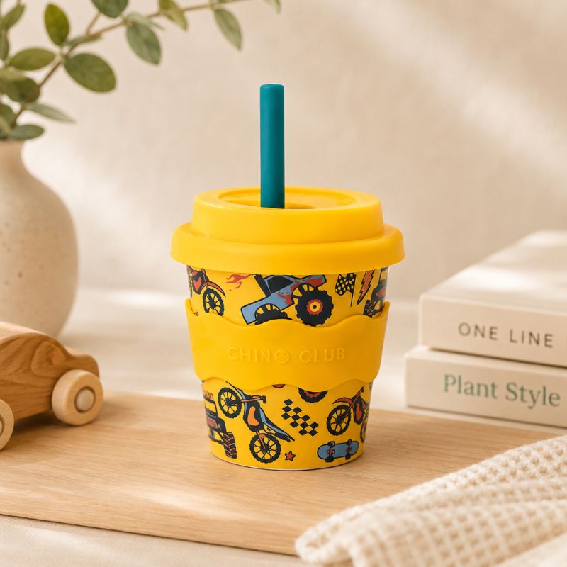 Wheelies Babychino Cup (4 oz) and blue straw on a wooden surface.