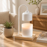 A modern White & Wood Arched Candle Warmer Lamp with a frosted glass candle holder and a light wood base, styled on a wooden table in a cozy living room setting.