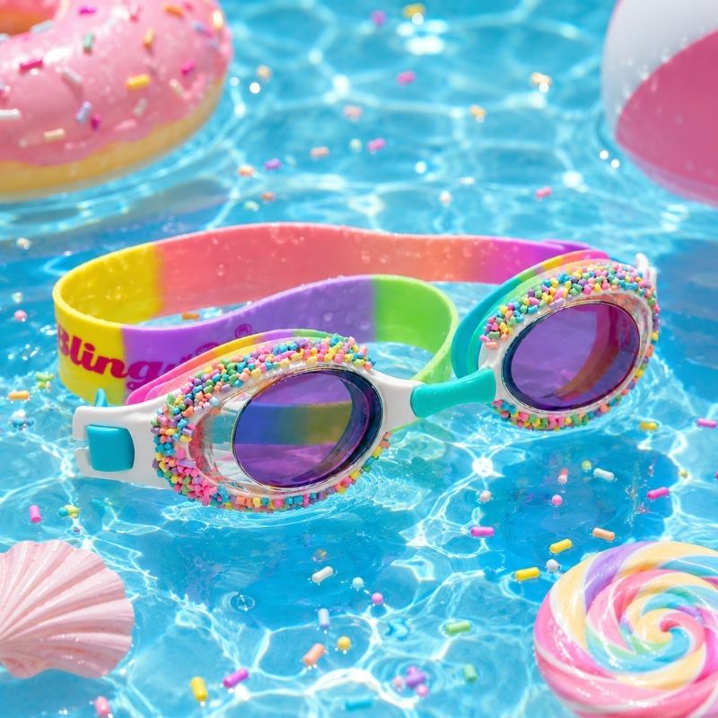 Whoopie Pie Cake Colorful swim goggles with sprinkles on a pool background with pool toys.