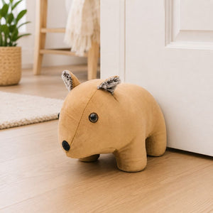 Wombat door stopper on a wooden floor
